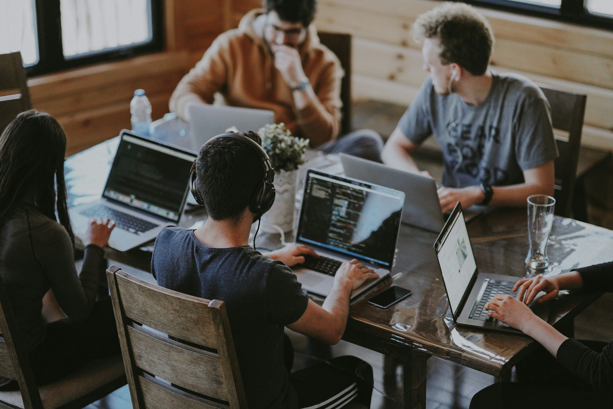 A small team gathered around a laptop at a shared desk